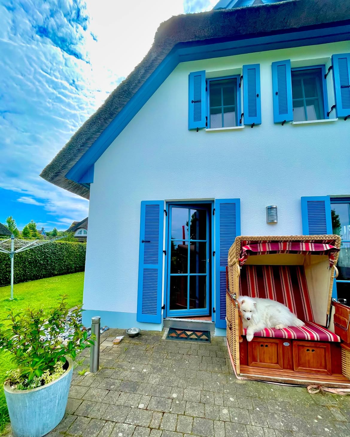 Reetdachhaus mit blauen Fensterläden und Strandkorb auf Rügen