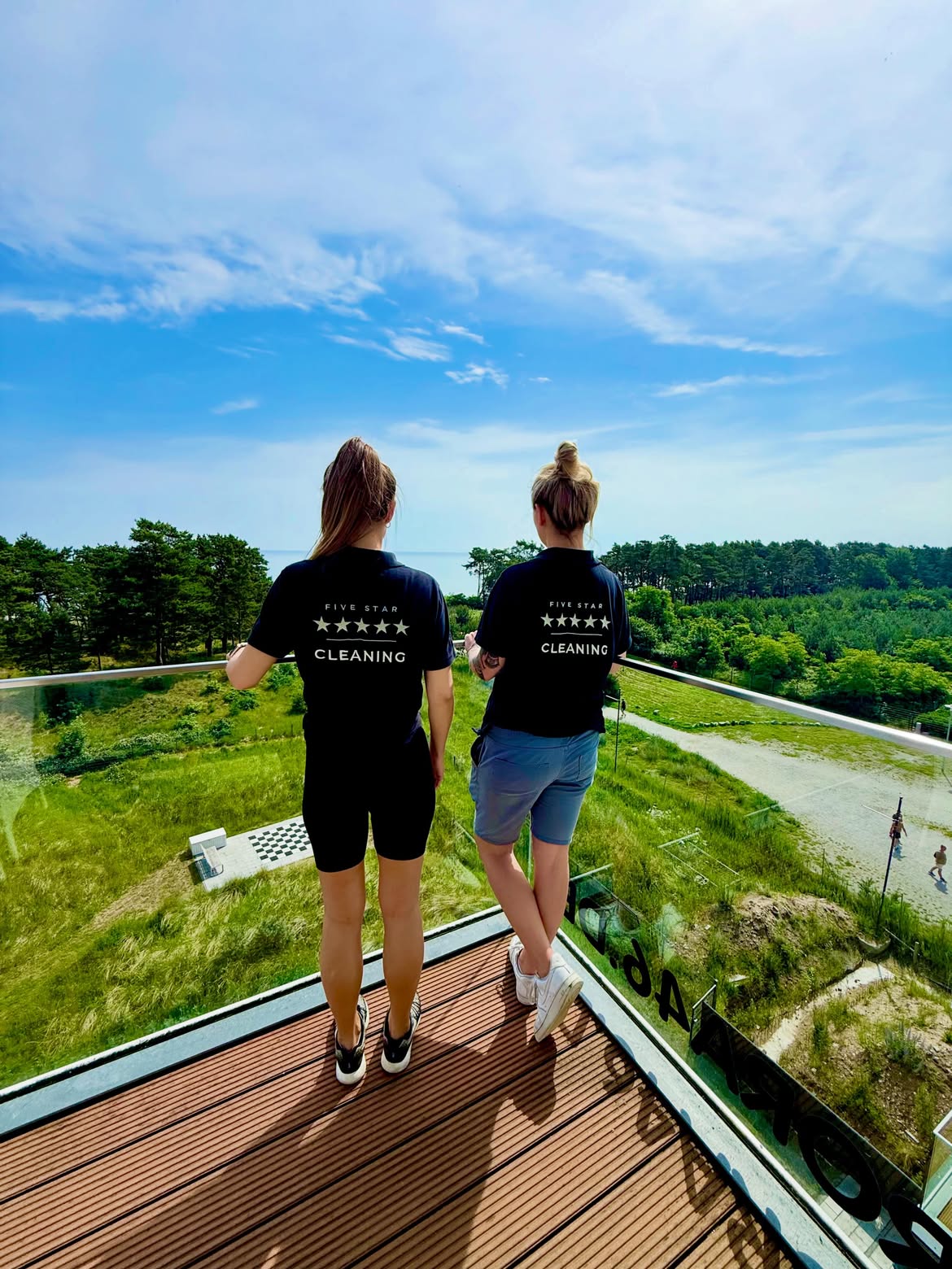 Das Team von Five Star Cleaning auf einem Balkon über der Ostseeküste